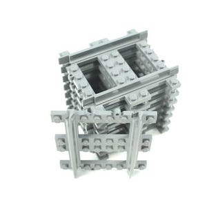 May include: A collection of gray plastic toy train tracks and building blocks, stacked and arranged against a white background. The tracks are designed to interlock, suggesting a construction or building toy theme.