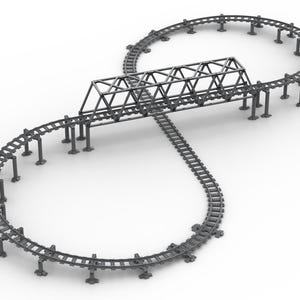 May include: A gray toy roller coaster track set in a figure-eight configuration. The track includes a bridge structure and support columns. The set is designed for toy cars and is set against a white background.
