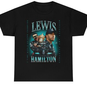 K&ouml;nnte beinhalten: Schwarzes T-Shirt mit einem Grafikdruck des Formel-1-Fahrers Lewis Hamilton, der eine Troph&auml;e h&auml;lt. Der Text "Lewis Hamilton" ist in Wei&szlig; mit t&uuml;rkisfarbenem Umriss gedruckt. Die Texte "7 Time World Drivers Champion" und "Mercedes-AMG Petronas" sind in Wei&szlig; an den Seiten des Grafikdrucks gedruckt.