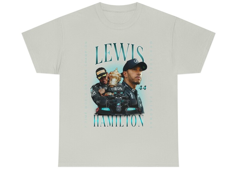 K&ouml;nnte beinhalten: Ein hellgraues T-Shirt mit einer Vintage-Grafik des Formel-1-Fahrers Lewis Hamilton, der eine Troph&auml;e h&auml;lt. Der Text "Lewis Hamilton" ist in blauer Schrift gedruckt.