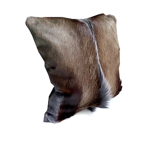 May include: A brown and gray fur pillow with a white stripe down the center.