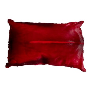 Op de afbeelding: Een rood nep bont kussen met een lange, dunne, lichtrode streep in het midden.