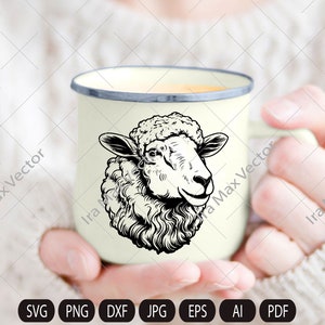Puede incluir: Una taza de esmalte blanco con una ilustraci&oacute;n en blanco y negro de la cabeza de una oveja. La oveja tiene un abrigo blanco y esponjoso y una nariz negra.