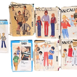 May include: A collection of vintage sewing patterns featuring illustrations of clothing designs for boys and men. The patterns are from brands like Simplicity and McCall's, with text including pattern numbers and brand names. The patterns showcase various styles from the 1970s.