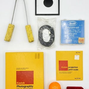 May include: A white ceramic mug with a black handle and the text "But First, Coffee" in a handwritten style. The mug is on a white surface. The mug is approximately 4 inches tall.
