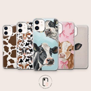 May include: A collection of five clear smartphone cases featuring various cow-themed designs, including brown and white cow spots, a pattern of multiple cow faces, a black and white cow on a blue background, and a brown calf with pink bows.