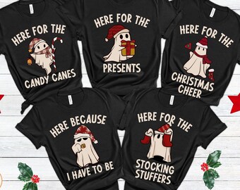 May include: Black t-shirts with Christmas ghost graphics. Each shirt features a different ghost design with text: "Here for the Candy Canes," "Here for the Presents," "Here for the Christmas Cheer," "Here Because I Have to Be," and "Here for the Stocking Stuffers."
