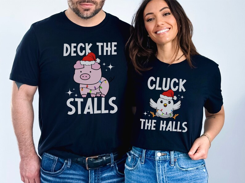 Peut inclure: Deux t-shirts noirs avec un motif sur le th&egrave;me de No&euml;l. Le premier t-shirt repr&eacute;sente un cochon portant un chapeau de P&egrave;re No&euml;l et le texte "Deck the Stalls". Le deuxi&egrave;me t-shirt repr&eacute;sente un poulet portant un chapeau de P&egrave;re No&euml;l et le texte "Cluck the Halls".