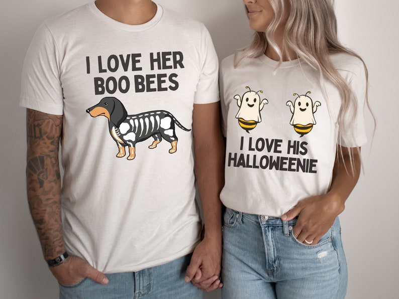 May include: Two white t-shirts with a Halloween-themed couple's design. The first shirt features a black and white dachshund with the text "I love her boo bees". The second shirt features two ghost bees with the text "I love his Halloweenie".