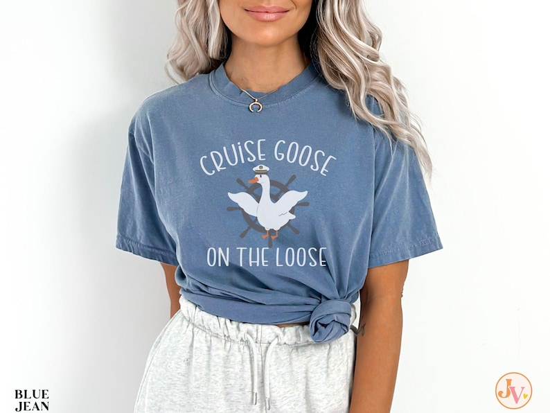 Puede incluir: Una camiseta azul con un ganso blanco que lleva un gorro de capit&aacute;n y el texto "Cruise Goose on the Loose".