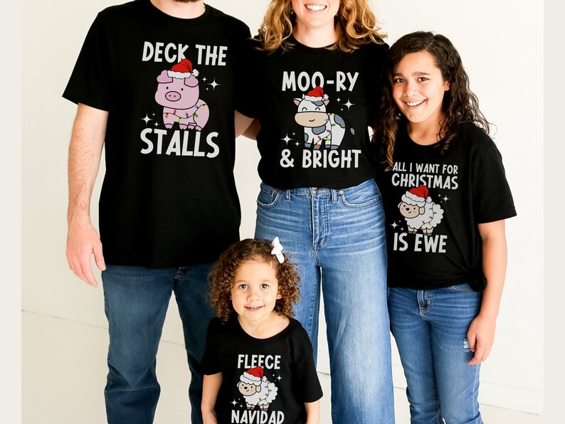 Peut inclure: Une famille de quatre personnes portant des t-shirts assortis sur le th&egrave;me de No&euml;l. Les t-shirts repr&eacute;sentent un cochon, une vache, un mouton et un mouton avec un chapeau de P&egrave;re No&euml;l. Le texte sur les t-shirts est "Deck the Stalls", "Moo-ry & Bright", "All I Want for Christmas is Ewe", et "Fleece Navidad".