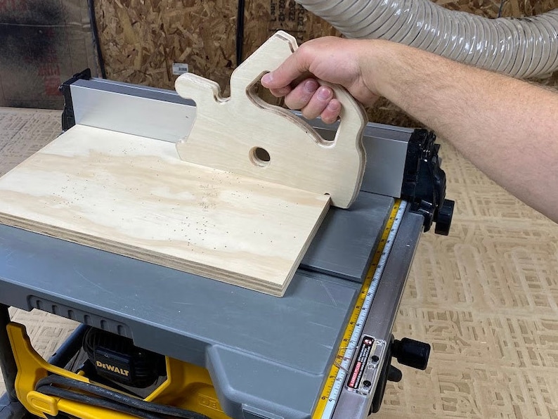 Downloadable PDF file for printing to legal size printer paper to cut out of wood a push stick in the shape of a circular saw for using on a table saw.