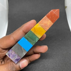 Może przedstawiać: Szpiczasty kryształ w kolorze tęczy z siedmioma kolorami: fioletowym, czarnym, niebieskim, zielonym, żółtym, pomarańczowym i czerwonym.