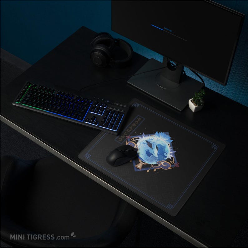 May include: A black computer desk setup with a backlit keyboard, mouse, and mousepad featuring a blue and white graphic. A black monitor and headphones are also visible. The desk is dark, and the overall theme is gaming.