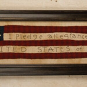 May include: A framed needlepoint piece depicting an American flag with the words "I Pledge Allegiance to the Flag of the United States of America".