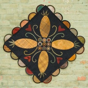 May include: A black wool rug with a geometric design featuring four yellow pineapples, red hearts, and green swirls. The rug has a scalloped border with alternating colors of red, orange, yellow, green, blue, and purple.