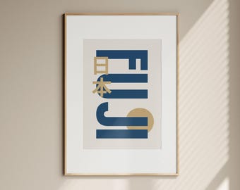 May include: Framed art print featuring a minimalist design with the word "FUJI" in navy blue, with Japanese characters and a gold sun. The artwork is set against a cream background, framed in a light wood.