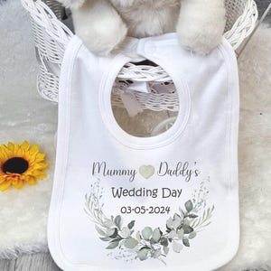 May include: White bib with a green floral design and the text "Mummy Daddy's Wedding Day 03-05-2024".