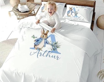 Juego de ropa de cama infantil personalizado con edredón azul y cesta de juguetes a juego para habitación de bebé.