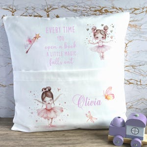 Op de afbeelding: Wit kussen met een zak, met illustraties van ballerina's, vlinders en een toverstaf. De tekst luidt "Every time you open a book a little magic falls out" en de naam "Olivia".