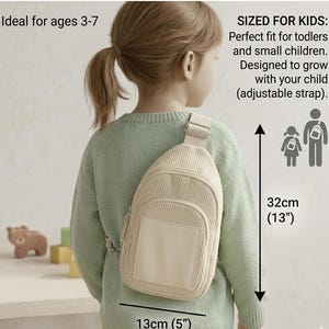 Puede incluir: Un bolso bandolera de pana beige, de 13 cm de ancho y 32 cm de alto, usado por un ni&ntilde;o. El bolso tiene un bolsillo frontal y una correa ajustable. La imagen incluye el texto "SIZED FOR KIDS" y "Ideal for ages 3-7".