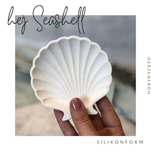 Könnte beinhalten: Weiße Muschelform aus Silikon zum Basteln. Die Form ist mit Rippen und einer glatten, glänzenden Oberfläche detailliert.