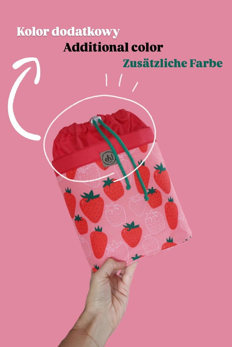 Pode incluir: Uma bolsa com cord&atilde;o com a parte superior vermelha e o corpo rosa. O corpo da bolsa &eacute; estampado com morangos vermelhos. O cord&atilde;o &eacute; verde. O texto "Additional color" est&aacute; no topo.