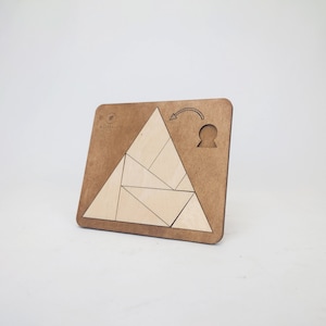 May include: A wooden triangle puzzle with a light brown background and a light wood triangle shape that is divided into smaller triangles. The puzzle is designed to be assembled into a larger triangle shape. The puzzle is made of wood and has a light brown finish.