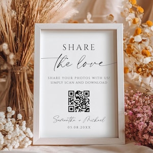 May include: A framed sign with the words "SHARE the love" in elegant script. The sign includes a QR code and the text "SHARE YOUR PHOTOS WITH US! SIMPLY SCAN AND DOWNLOAD". Below the QR code is the text "Samantha + Michael" and a date.