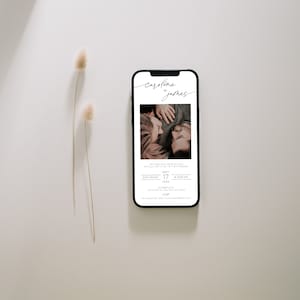 May include: A mobile phone screen displaying a wedding invitation for Caroline and James. The invitation features a photo of the couple, the date, and time of the wedding. The invitation is in a minimalist style with a white background and black text.