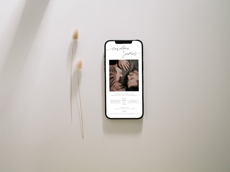 May include: A mobile phone screen displaying a wedding invitation for Caroline and James. The invitation features a photo of the couple, the date, and time of the wedding. The invitation is in a minimalist style with a white background and black text.