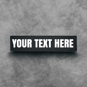 May include: Black fabric patch with white text that reads "YOUR TEXT HERE".
