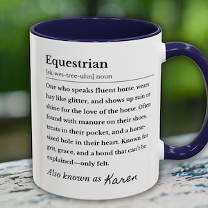 以下が含まれることがあります： ネイビーブルーの内側とハンドルが付いた白いセラミックマグ。マグには「Equestrian」の定義と、馬好きを説明するテキストが記載されています。テキストには「Also known as Karen」というフレーズが含まれています。