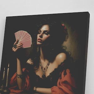 May include: A woman in a red and black dress holds a fan of playing cards in her hand. She is sitting at a table with a spread of tarot cards in front of her. The background is dark and moody.