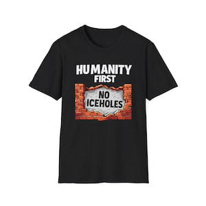 Peut inclure: T-shirt noir avec l'inscription "HUMANITY FIRST" au-dessus d'un graphisme de mur de briques avec un panneau indiquant "NO ICEHOLES". Le design est en blanc, rouge et gris.