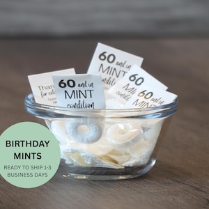 May include: A clear glass bowl filled with white mint candies and small white cards. The cards read "60 and in MINT condition." A green circle with the words "BIRTHDAY MINTS" is in the lower left.