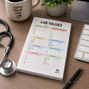 May include: A stack of 50 white lab value sheets with colorful sections for test results. The title "LAB VALUES" is at the top. A stethoscope, a coffee mug with "COFFEE FUELED CARE" text, a pen, and a keyboard are also visible.