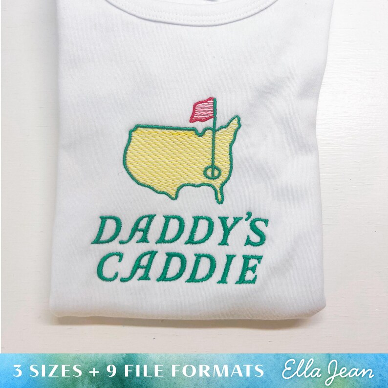 May include: White t-shirt with green embroidery of a golf course and the text "Daddy's Caddie".