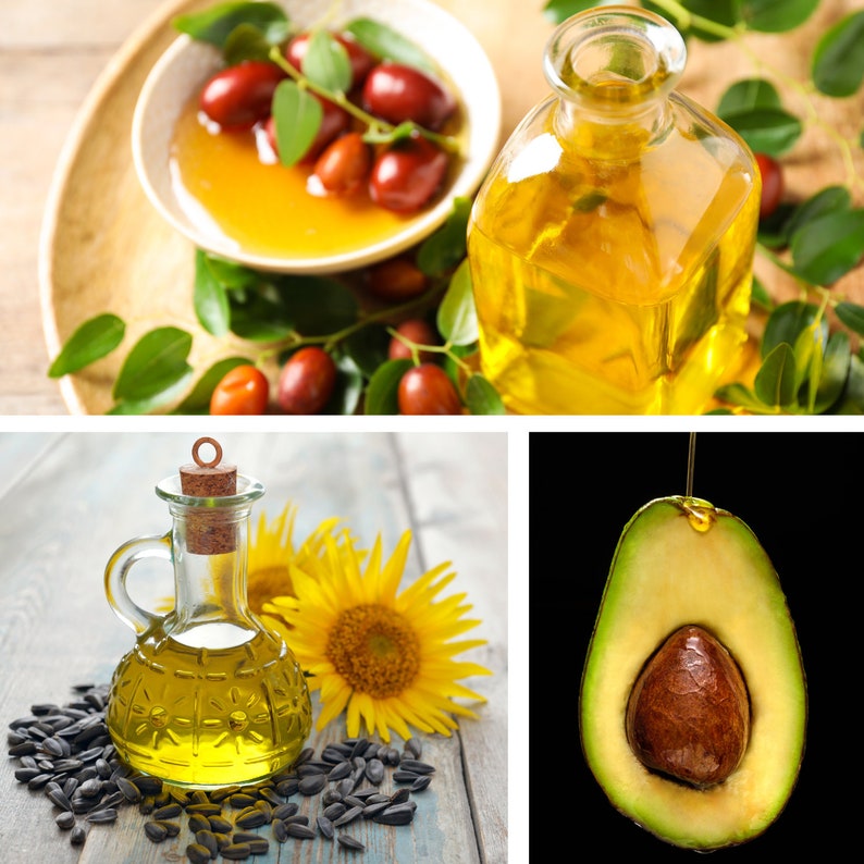 Op de afbeelding: Drie glazen flessen met olie met verschillende ingredi&euml;nten: jojoba, zonnebloem en avocado. De flessen staan op een houten oppervlak met de ingredi&euml;nten eromheen.