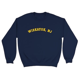 May include: A navy blue sweatshirt with the text "WISKAYOK, NJ" in yellow arched lettering across the chest. The sweatshirt has long sleeves and a crew neck.