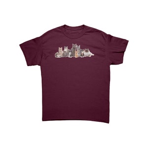 May include: Burgundy t-shirt featuring a graphic of various cat breeds. The cats are in a row, with a variety of colors and patterns, including gray, brown, and white. The shirt is made of a soft material.
