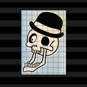 May include: A black and white cartoon skull wearing a bowler hat. The skull has a large black eye and a wide open mouth. The background is a light blue grid pattern, with a black and white striped border.