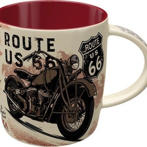 May include: Cream-colored ceramic mug featuring a vintage motorcycle graphic with the text "ROUTE US 66." The mug has a burgundy interior and a curved handle. The design includes a Route 66 sign and map elements.