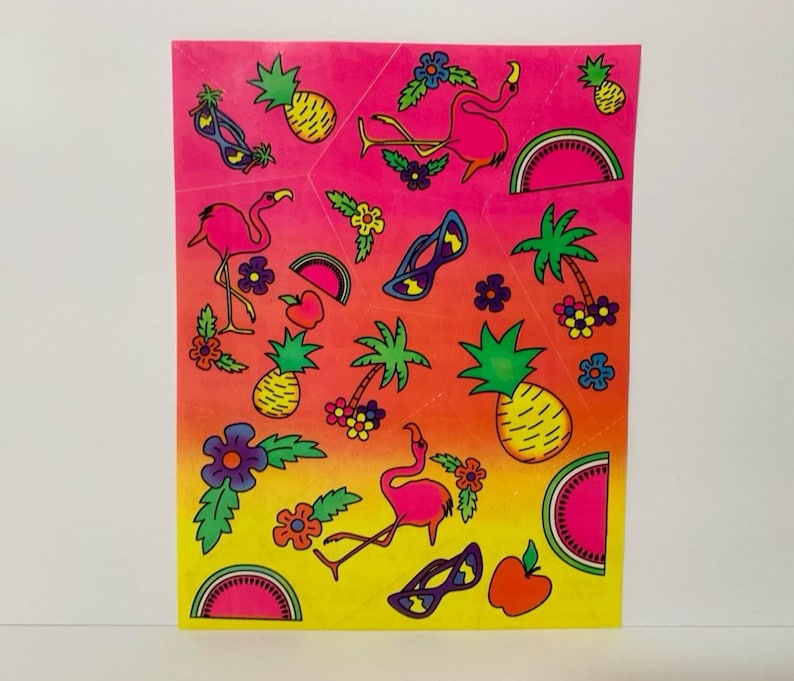 May include: A sheet of colorful stickers featuring pink flamingos, pineapples, palm trees, sunglasses, watermelons, and apples. The stickers are on a gradient background that transitions from pink to yellow.