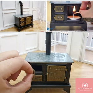 Puede incluir: Mini estufa negra y latón con tapa plateada y chimenea. La estufa tiene dos puertas y un cajón, con herrajes decorativos de latón. La parte superior presenta diseños de quemadores circulares. Una cerilla enciende una vela en el interior.