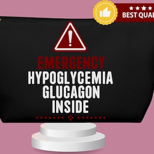 Può includere: Pochette nera con cerniera con la scritta "EMERGENCY HYPOGLYCEMIA GLUCAGON INSIDE" in bianco e rosso. Un triangolo rosso con un punto esclamativo è sopra il testo. Un badge dorato "Best Quality" è nell'angolo in alto a destra.