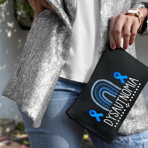 May include: Black clutch bag with a blue ribbon and the text "DYSAUTONOMIA..." in white. The bag has a rainbow design with blue, white, and black colors.