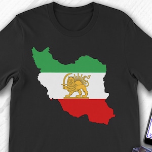 Puede incluir: Camiseta negra con un mapa de Irán en verde, blanco y rojo, con un emblema de león dorado. La camiseta se muestra con vaqueros azules y un smartphone con el logotipo de Etsy.