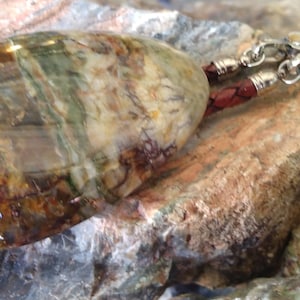 Petrified Wood Bolo has feather tips with matching petrified wood cabochons