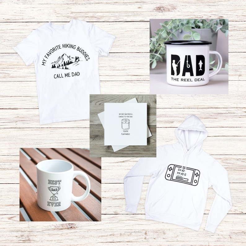 Op de afbeelding: Een set vaderdagcadeaus met een wit T-shirt met de tekst "My Favorite Hiking Buddies Call Me Dad", een witte mok met de tekst "Best Dad Ever" en een trofee-afbeelding, een witte hoodie met een videogamecontroller-afbeelding, een witte kaart met de tekst "No one can hold a candle to you Dad You're Flammable!" en een witte emaille mok met de tekst "Dad The Reel Deal" en een visafbeelding.
